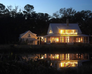 Lights reflected in pond behind house